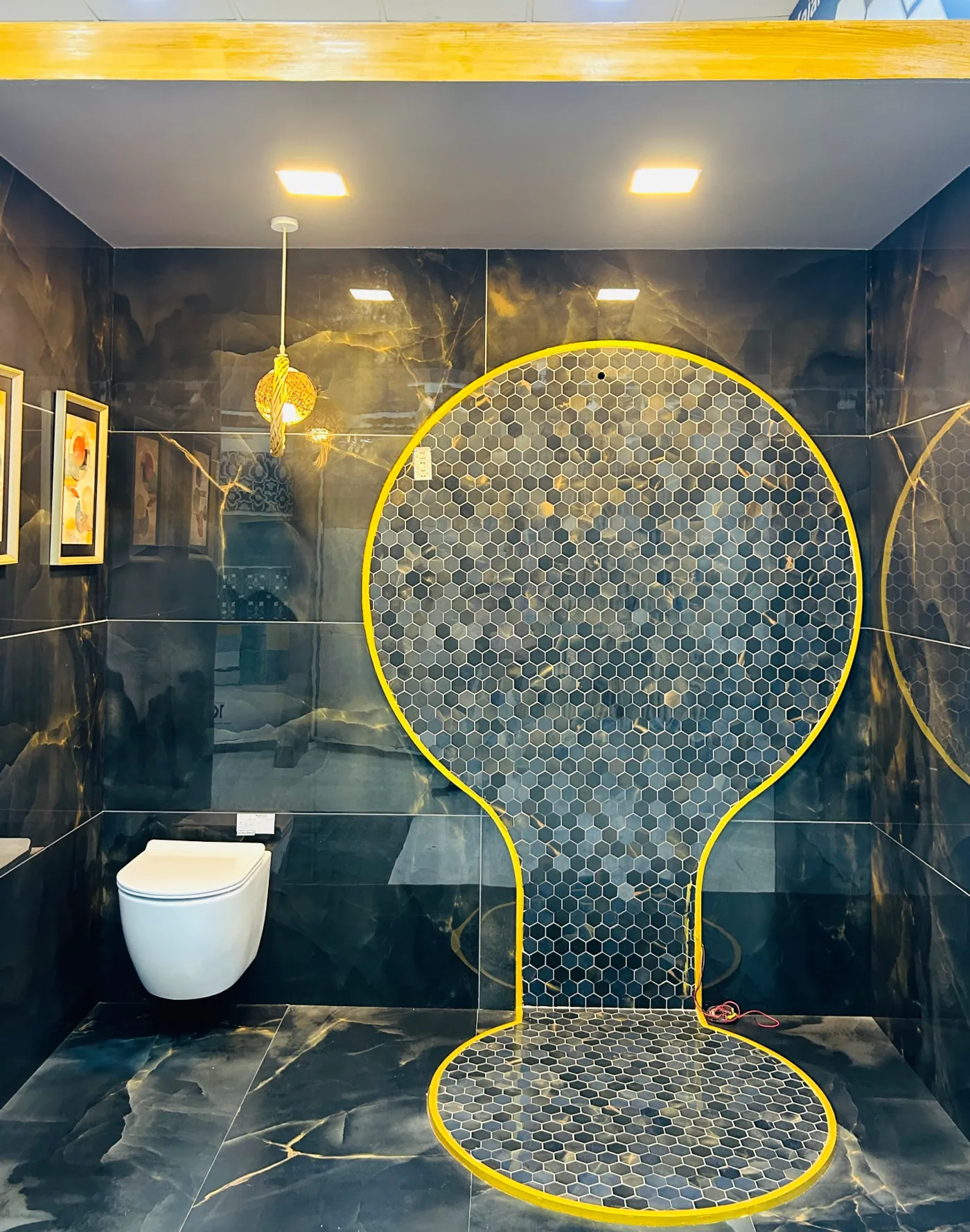 Black marble-look tile bathroom bay with hexagon mosaic feature circle and wall-hung WC