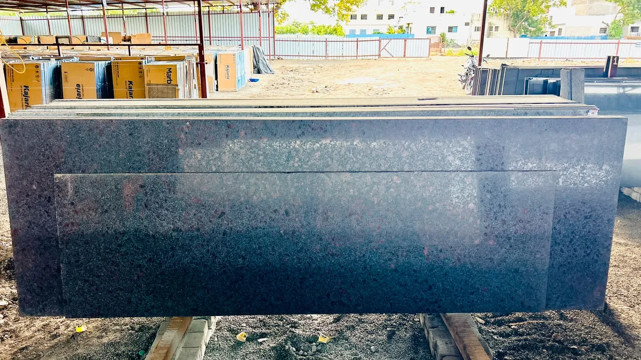 Dark multicolour granite slabs stacked in the open-sided covered stock yard