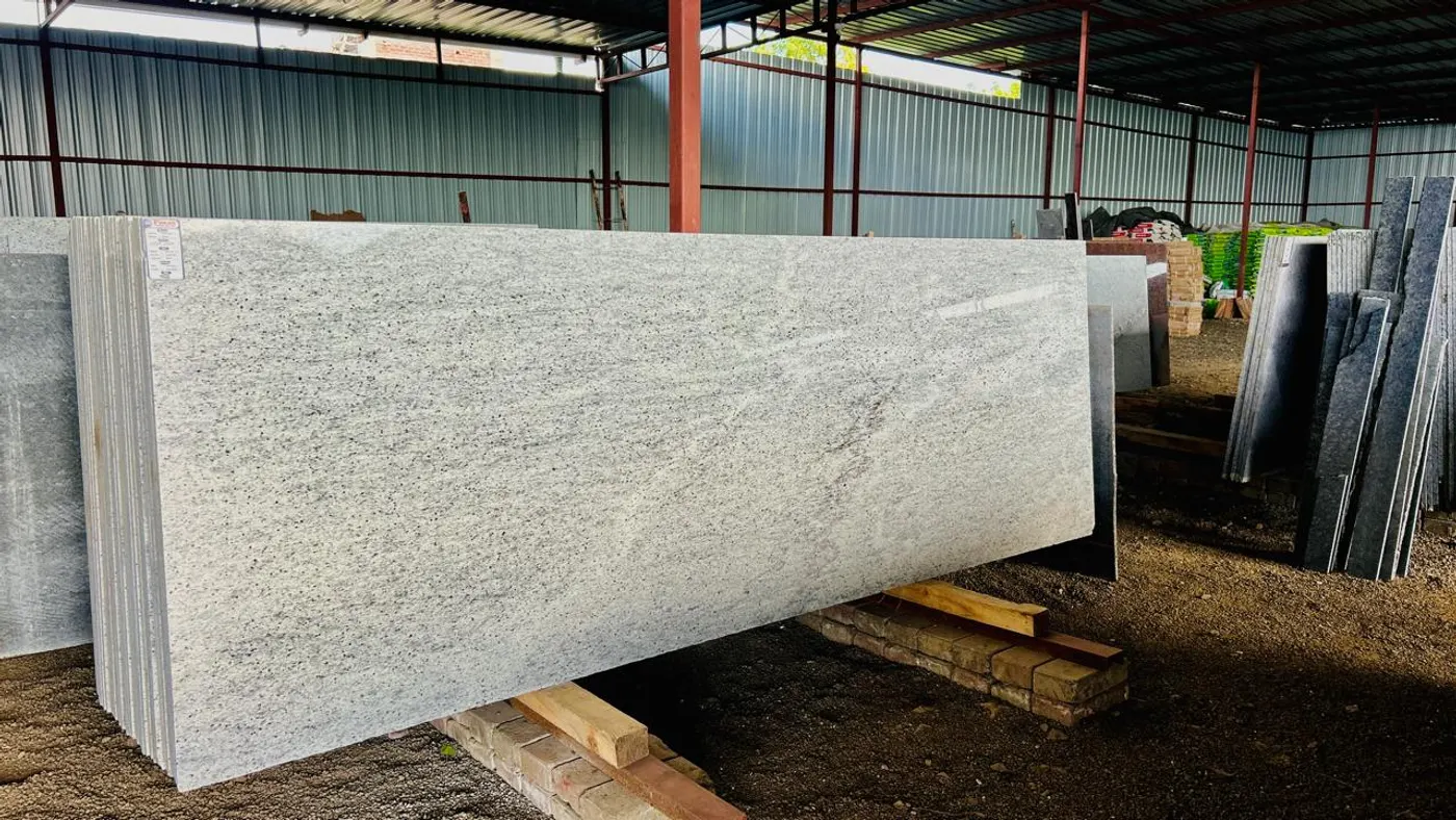 Full-size Moon White granite slabs ready for selection at the warehouse yard