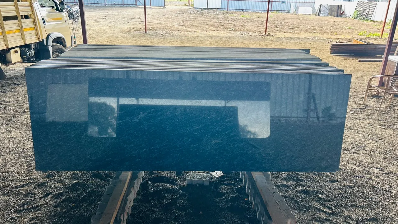 Stack of polished dark granite slabs displayed in the outdoor stock yard