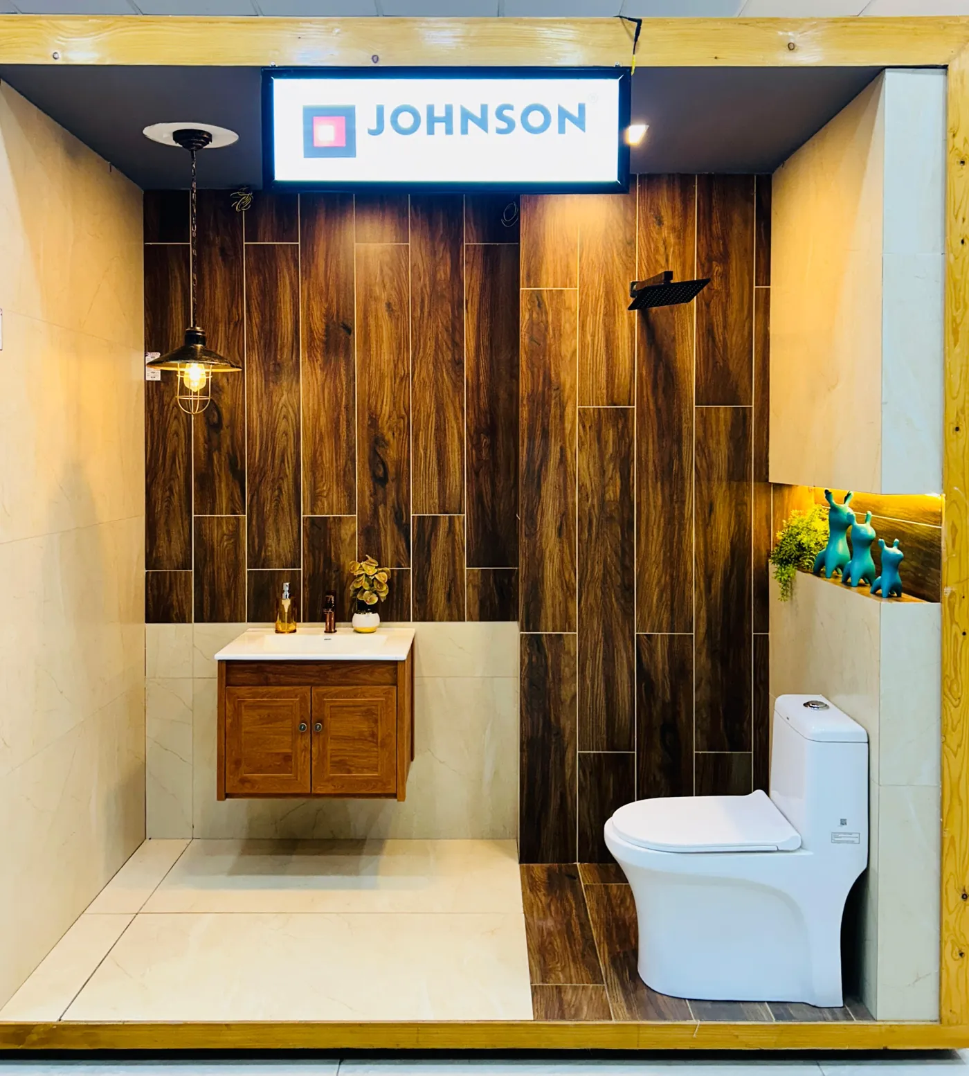 Johnson bathroom mock-up bay with wood-finish tile walls, vanity and one-piece water closet