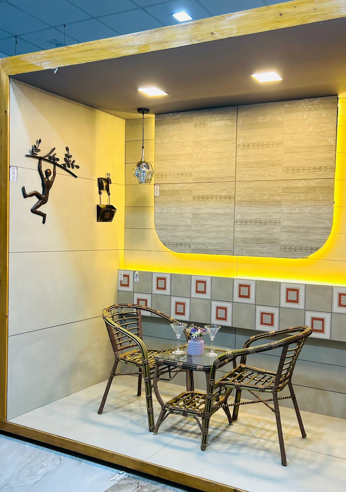 Dining mock-up bay with patterned wall tiles, backlit niche and cane furniture set